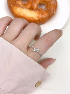 Detail shot of a s925 silver knot ring with bead textures worn on a finger