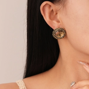 French vintage gold round stud earring with amber crystal on female model