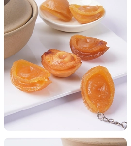 Detailed close-up of realistic faux abalone keychain with glossy resin texture and metal chain