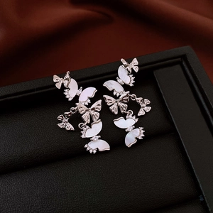 Détails de boucles d'oreilles papillons argentées à pampilles avec zircon et nacre