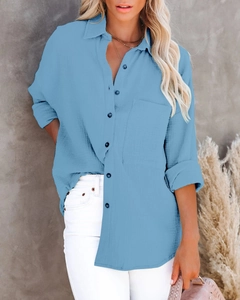 Detail of sky blue cotton linen shirt showing textured fabric and button-up closure