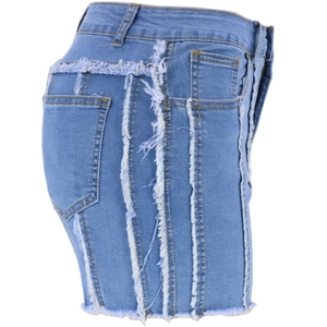 Detail view of high-waist denim shorts featuring stylish side fringe and raw hem edges