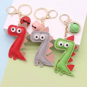 Three PU leather dinosaur keychains in red, gray and green with matching colorful bells