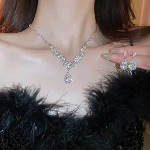 Luxury silver teardrop rhinestone necklace and earrings set worn by a model