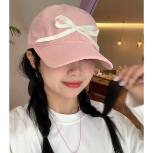 Pink cotton baseball cap with white ribbon bow and wide brim for a slim look