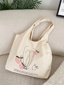 Minimalist canvas tote bag with peach graffiti illustration and text on a cozy sofa