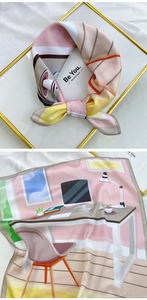 Close-up of silk square scarf featuring modern office illustration with hand-rolled edges