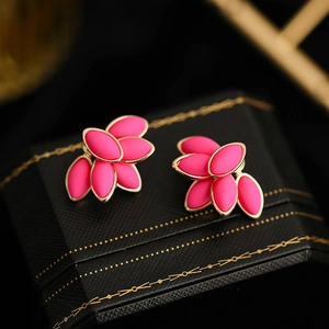 Detail of elegant rose pink floral stud earrings with gold plating on black box