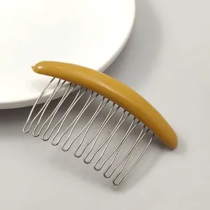 Detail of a bright yellow crescent hair comb with durable silver metal alloy teeth