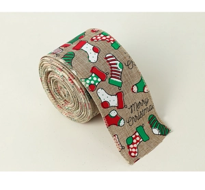 Close-up of faux linen Christmas ribbon rolls with festive stocking patterns and Merry Christmas text