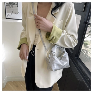Detail of silver metallic pleated mini bag with top handle and matching shoulder strap