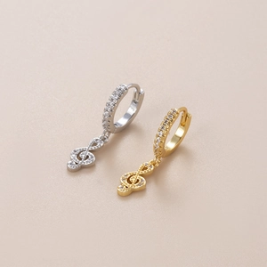 Detailed shot of gold and silver treble clef hoop earrings with sparkling zircon stones