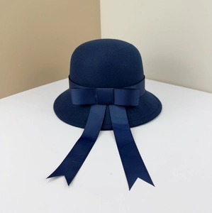 Detailed view of a dark blue wool cloche hat with a large ribbon bow and streamers.