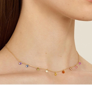 Close-up of gold chain necklace with colorful stones on model neck for elegant style