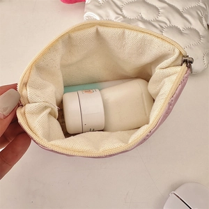 Close-up of pink quilted makeup bag interior showing storage space and beige lining