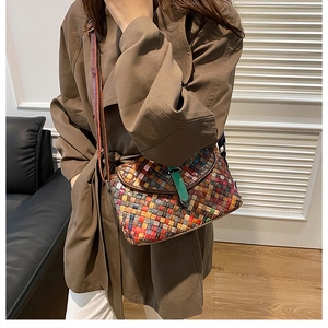 Détail d'un sac bandoulière tissé coloré avec une sangle brune et une boucle verte