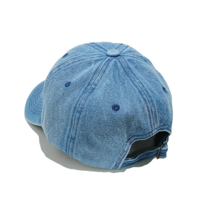Detail view of denim baseball cap with adjustable bronze metal buckle and stitching