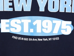 Detail of New York EST.1975 print on navy blue knit cotton vest showing fabric texture