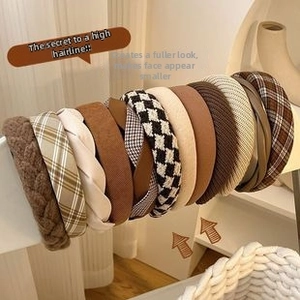 Close-up of assorted autumn velvet headbands in beige and brown tones on a display stand