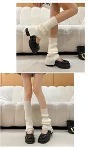 Close-up of ribbed white knit leg warmers paired with black Mary Jane platform shoes