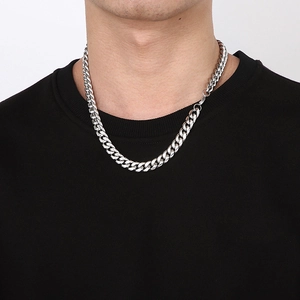 Close-up of polished silver titanium steel Cuban chain necklace on male model's neck