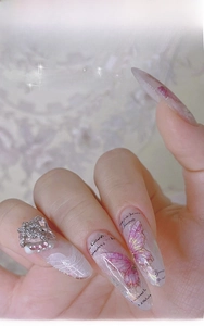 Macro detail of 3D butterfly nail art stickers with iridescent aurora finish and zircon gems