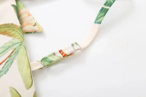 Détail de la boucle en métal argenté et de la bandoulière à imprimé floral tropical