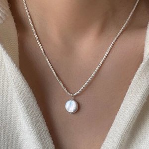 Detail showing irregular white baroque pearl pendant on a slim S925 silver chain