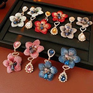 Vue détaillée des boucles d'oreilles fleurs en tissu vintage avec cristaux et pendentifs