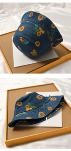 Detailed close-up of a blue denim baby sun hat featuring vibrant sunflower patterns