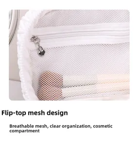Macro shot of white mesh makeup bag featuring heart-shaped zipper and brush storage