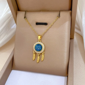 Macro view of dreamcatcher pendant with blue star stone and gold feathers on satin