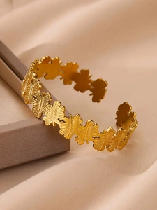 Détail du jonc ajustable en acier plaqué or 18K avec motif de feuilles texturées