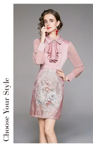 Close-up of pink satin dress featuring delicate floral embroidery and elegant ruffle collar