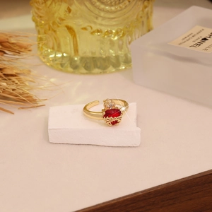 Detail of red heart gemstone ring with crown engraving and adjustable gold band
