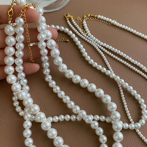 Detailed view of layered white pearls with gold adjustable lobster clasp and chain