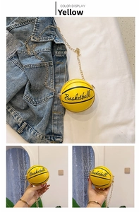 Close-up of yellow basketball-shaped crossbody bag with gold chain strap detail