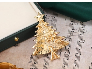Detailed back view of a golden Christmas tree brooch with star and secure pin closure