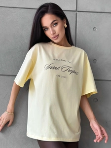 Detail of light yellow cotton T-shirt featuring Saint Tropez print on a loose fit top