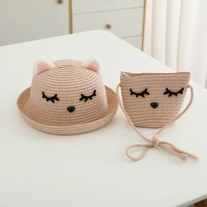 Dettaglio di cappello di paglia per bambini e borsa con ricamo di gatto e orecchie