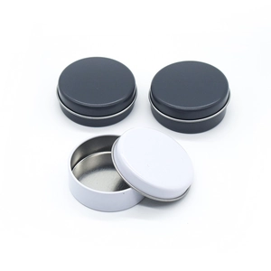 Set of round metal tin containers in white and dark grey for balm and cosmetics