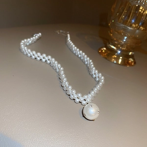 Close-up of double-layer woven pearl necklace with a rhinestone inlaid white pendant
