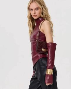 Détail d'un haut en cuir PU bordeaux avec gants et bracelet en métal doré