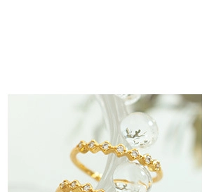 Macro detail of wave-shaped 18K gold plated ring with micro-pave zircon crystals