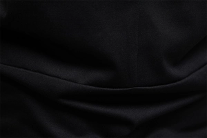 Macro detail of high-quality black fabric texture and fine stitching on a men's cotton t-shirt