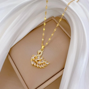 Detail of a swan pendant necklace with sparkling cubic zirconia on a beige jewelry box