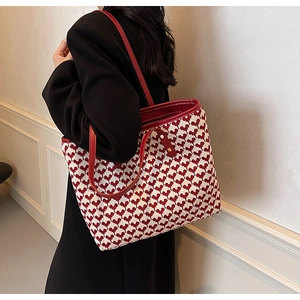 Close-up of red heart pattern woven fabric and leather handles on large tote bag