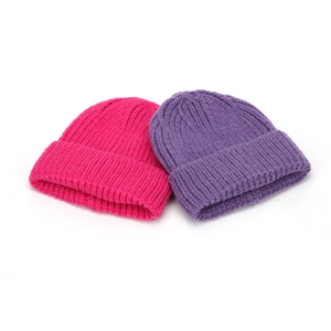 Vista dettagliata di due caldi cappelli di lana a maglia in fucsia e viola con bordo risvoltato