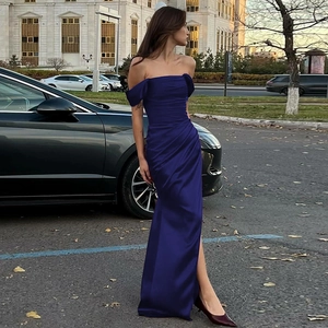 Dettaglio del tessuto in raso blu navy e dell'orlo a sirena dell'abito lungo da donna