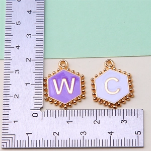 Detail showing 1.5cm hexagon enamel W and C letter charms with gold beaded edges